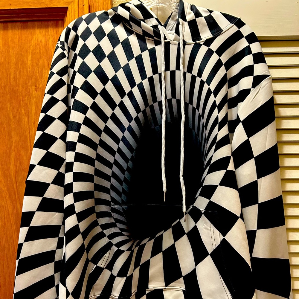 Graphic hoodie pullover with checkered black hole design.